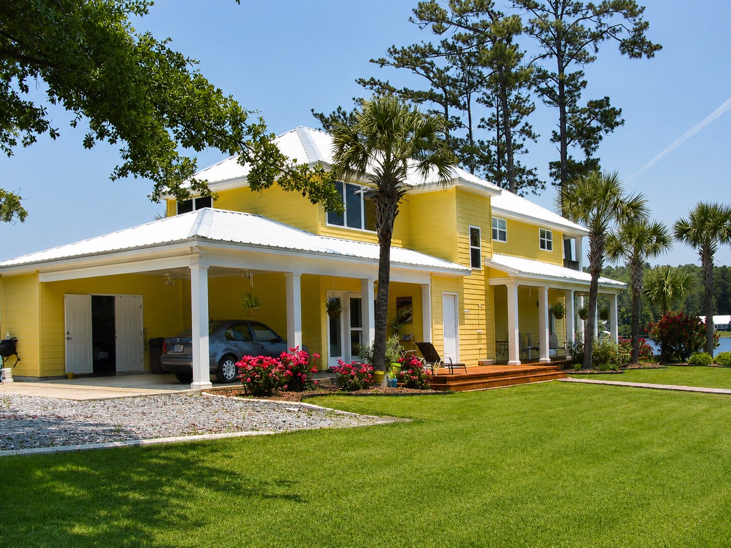Yellow coastal home with a bright white metal roof